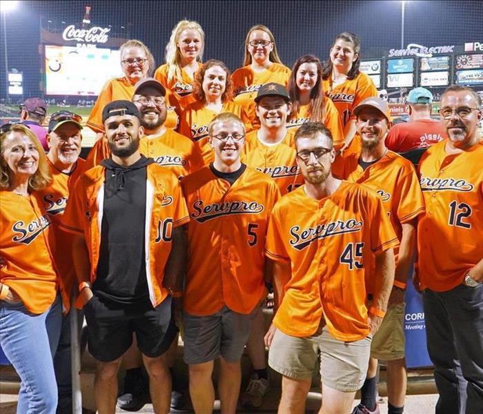 large group of employees in orange jerseys
