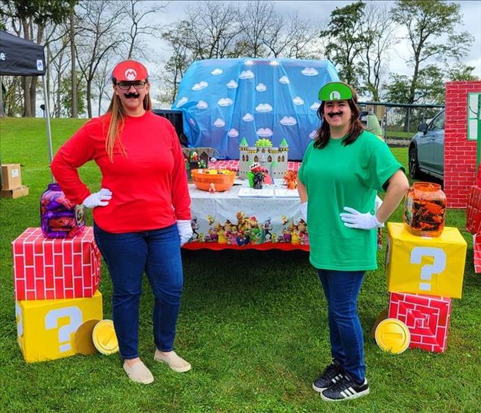 two ladies standing in front of a truck dressed up