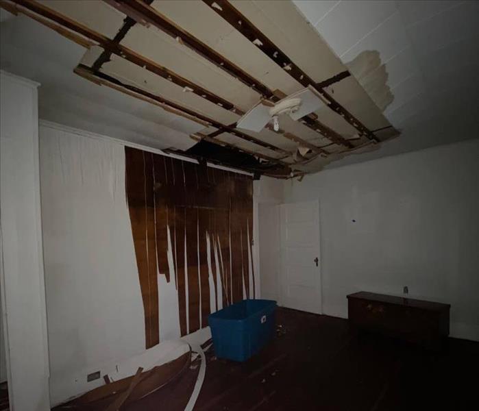 Damaged ceiling and wall in a bedroom. 