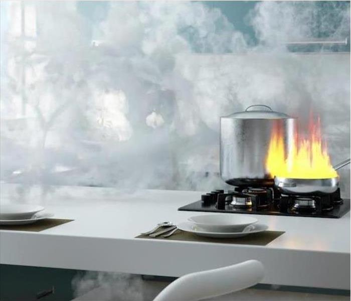 White countertop in kitchen with smoke and a stove-top fire