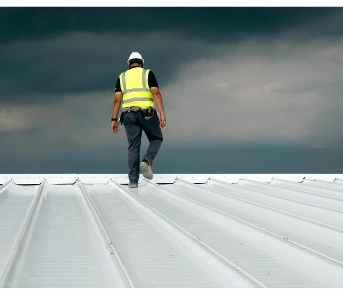 Construction engineer wearing safety uniform inspecting metal roofing work for roof industrial concept with copy space