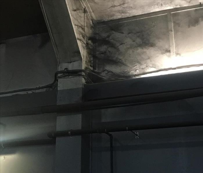 Photo depicting carbon webs in the corner of a residential structure due to fire damage